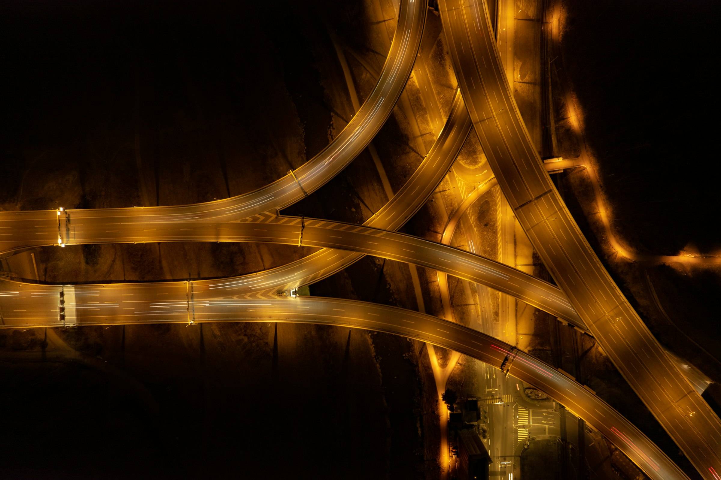Motorway junctions branching apart at night, from above