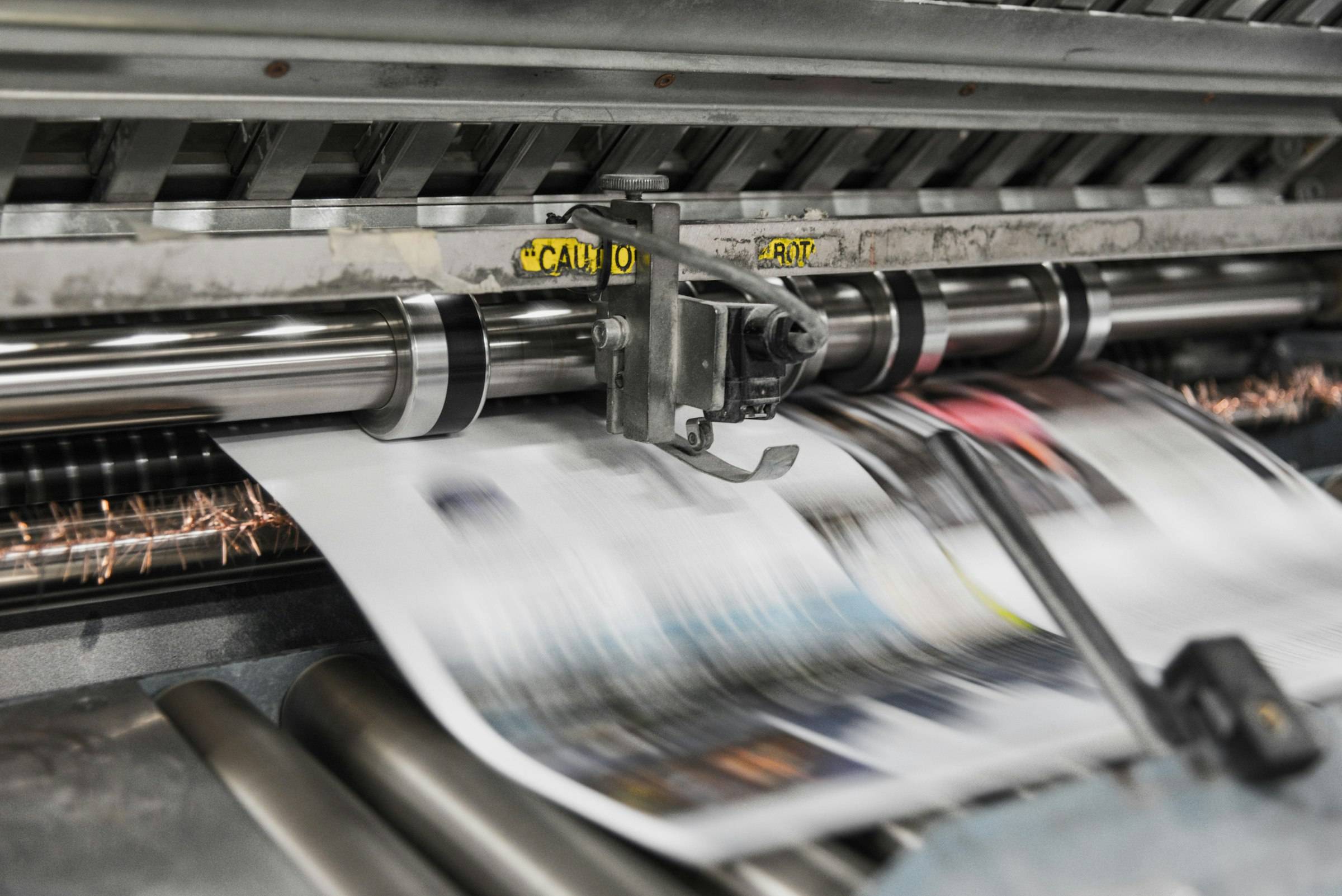 Newspapers running through a printing press